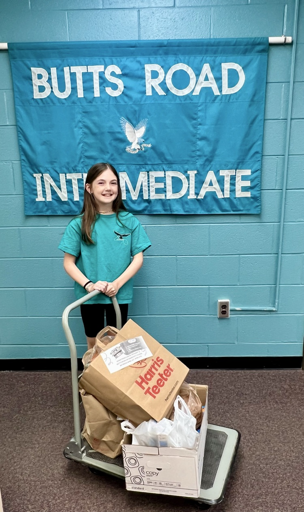 Student shown with cart of goods donated during our pet and food drive