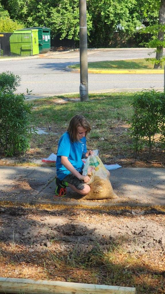 Child kneeling on sidewalk.