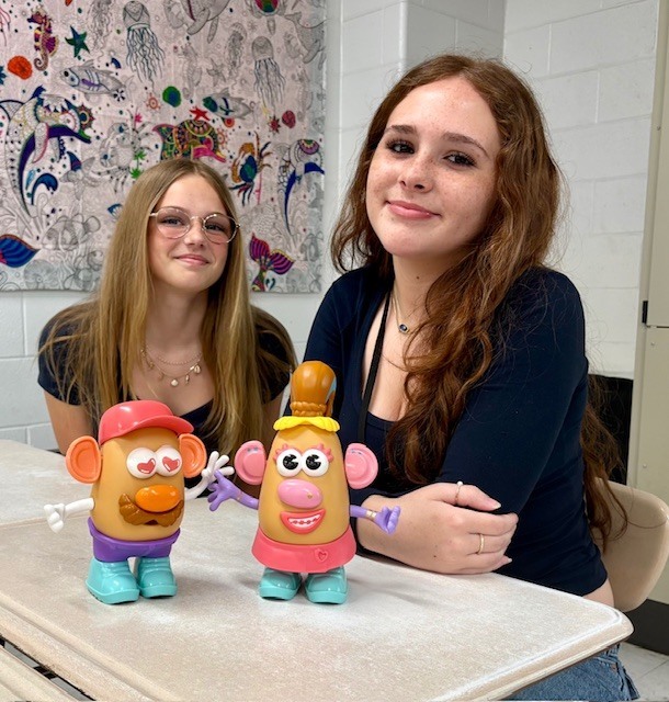 students smiling with their Mr. and Mrs. Potato Head creations