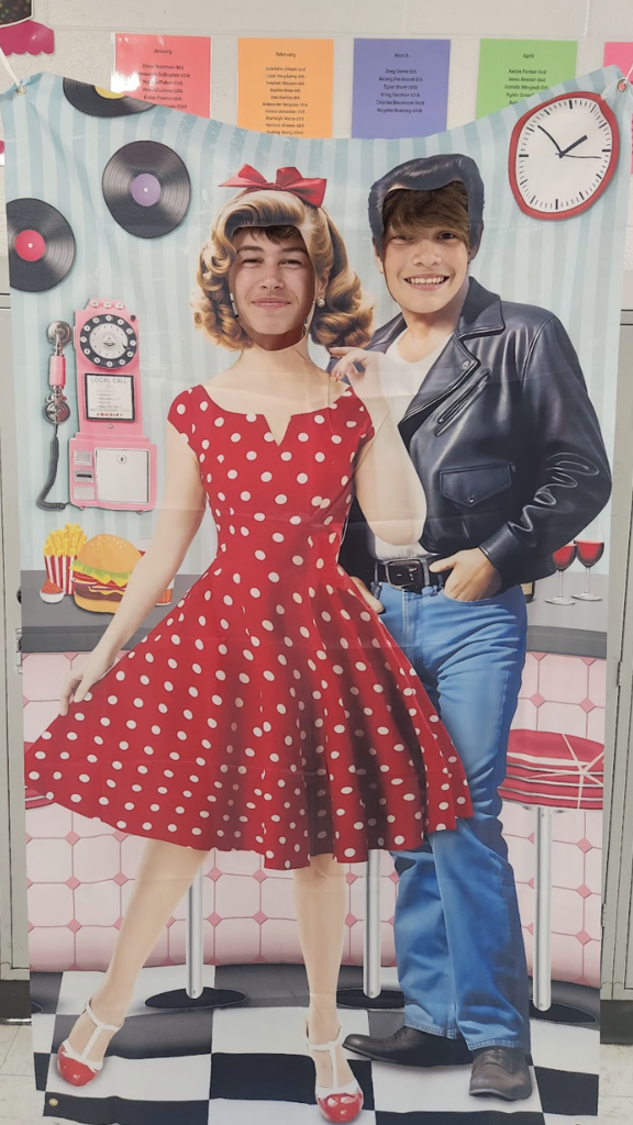 Students posing in a 1950s cut out poster