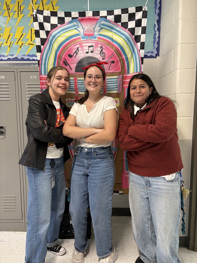 Students posing with 1950s backdrop