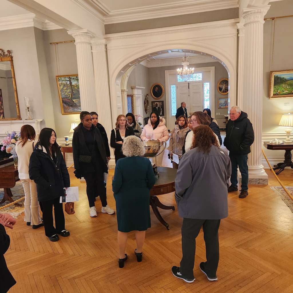 Young ladies being shown around the inside of the Governor's mansion