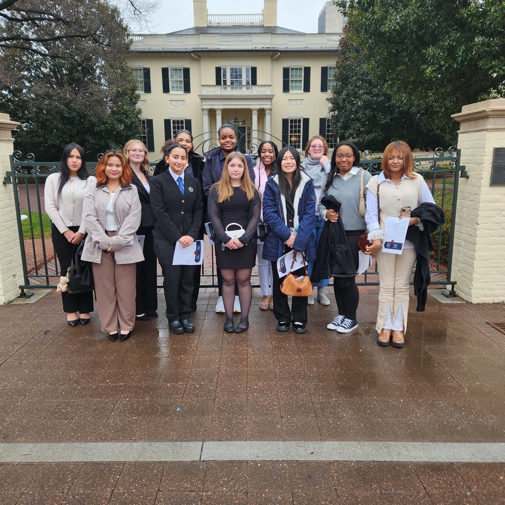 Young ladies smiling in front of the Governor's Mansion