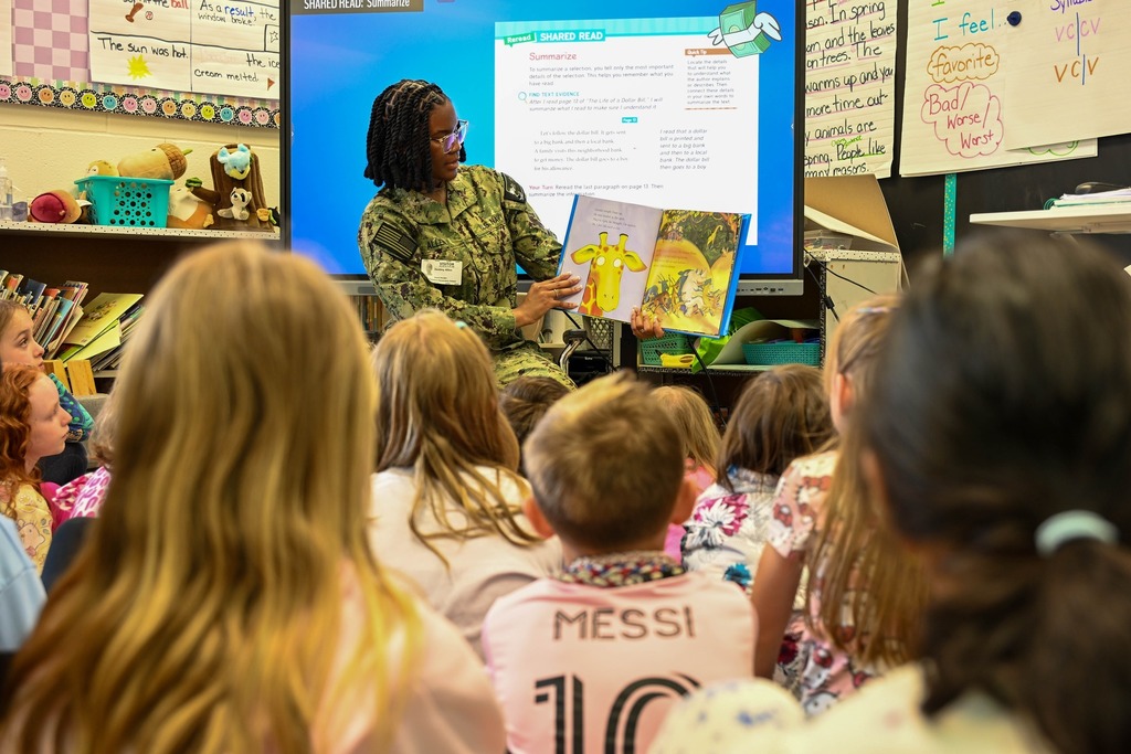 Military team for NSA proudly reads to  elementary students