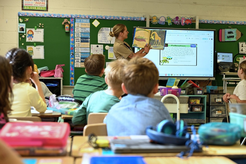 Military team for NSA proudly reads to  elementary students