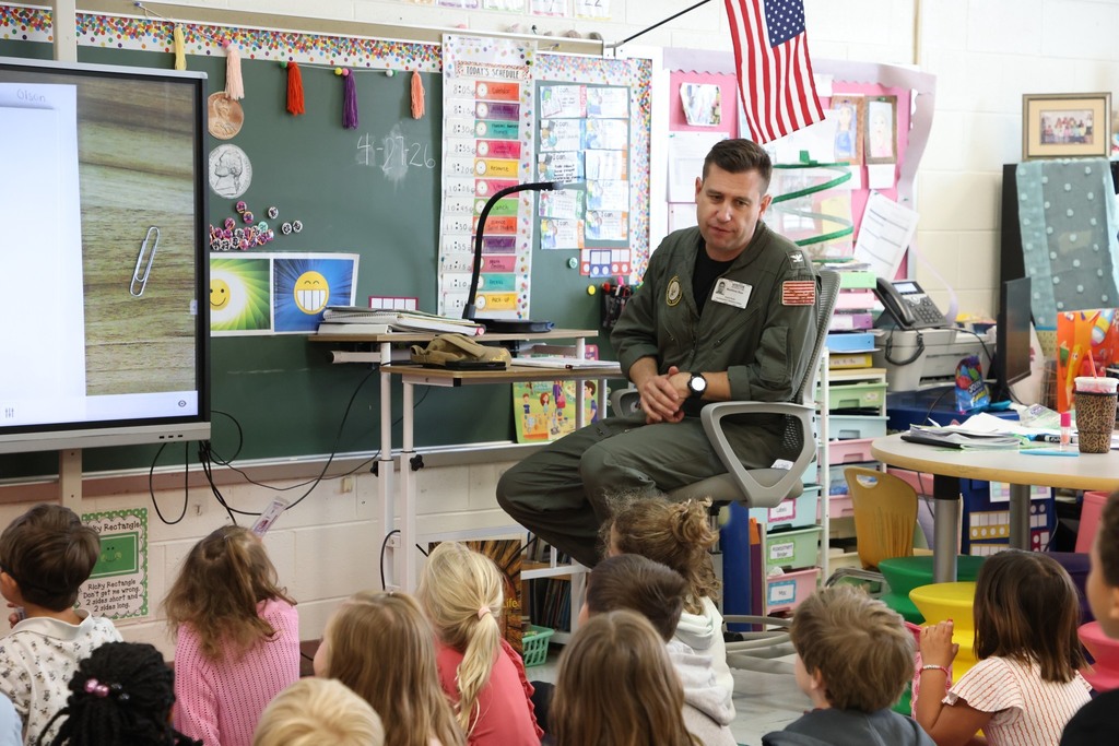 Military team for NSA proudly reads to  elementary students