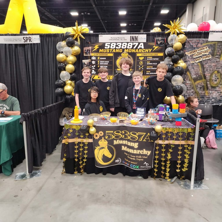 Group of robotic students posing for world champion standing at booth