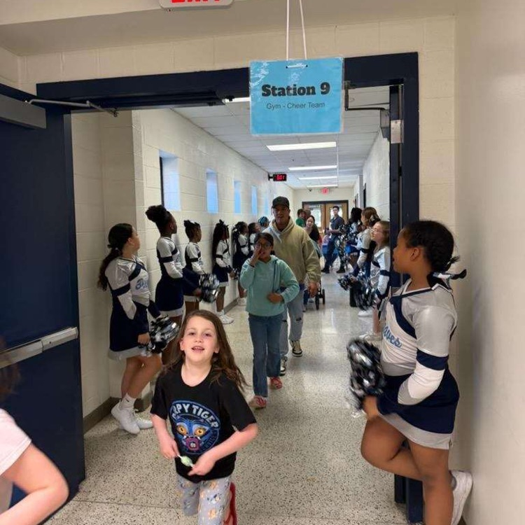 families entering from the gym surrounded by cheerleaders. 