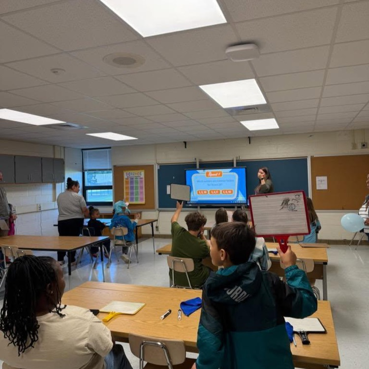 Students participating with mini white boards to answer questions. 