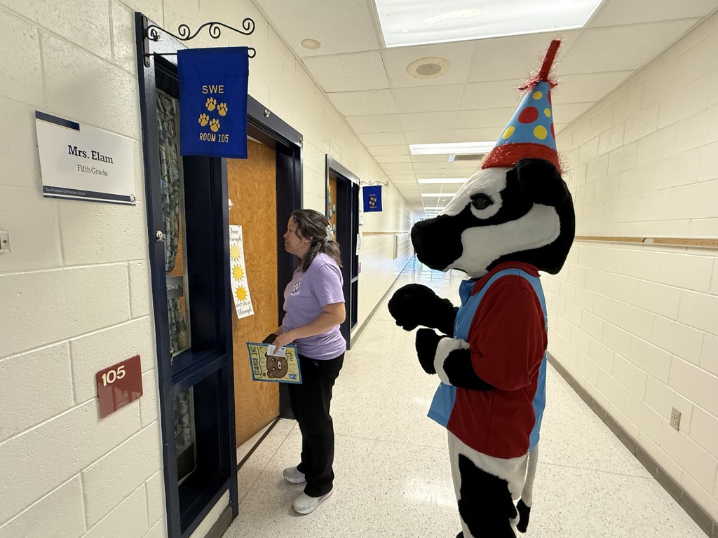student with the chick FIL a cow holding their yearbook cover