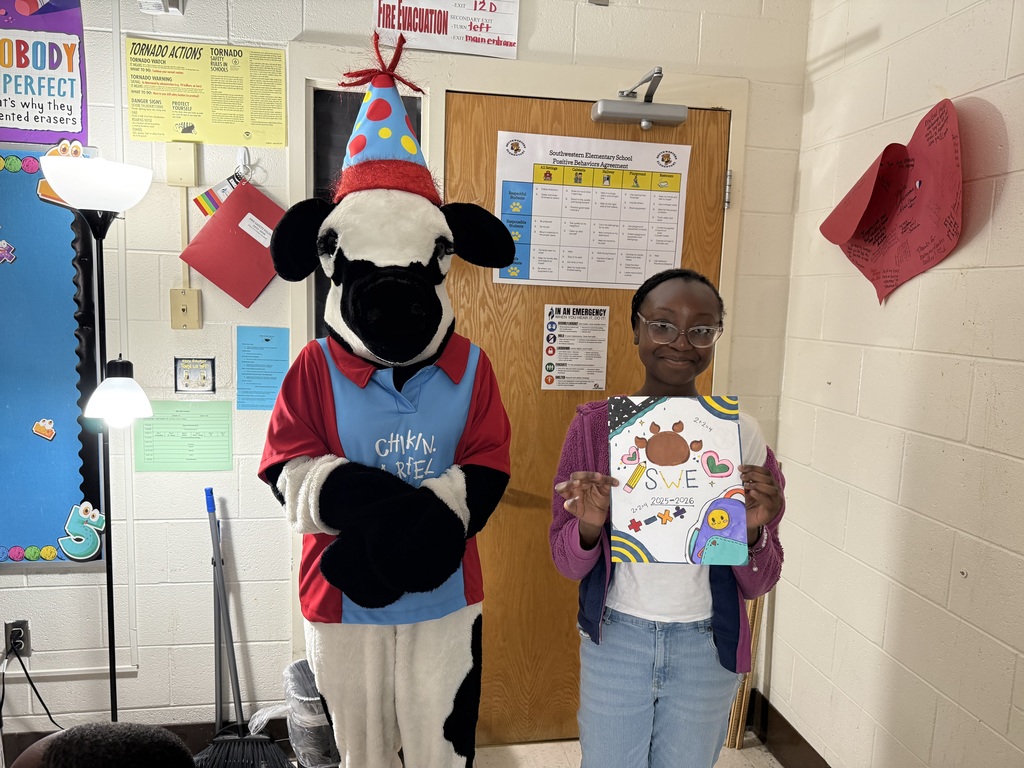 student with the chick FIL a cow holding their yearbook cover