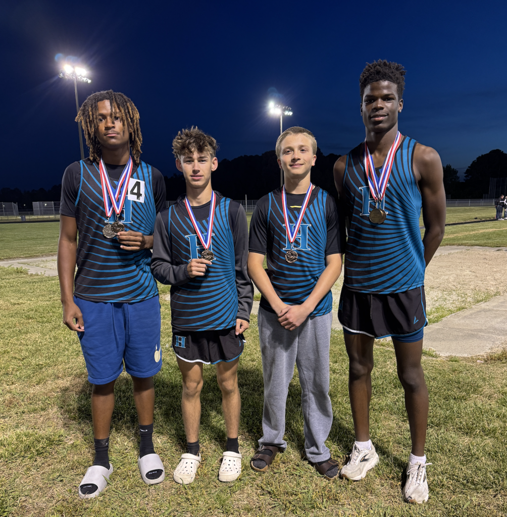 track student athletes proudly standing with their medal