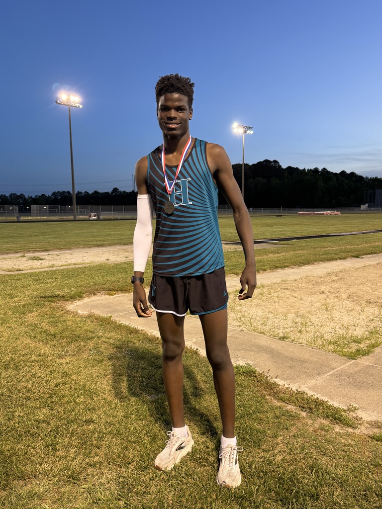 track student athlete proudly standing with their medal