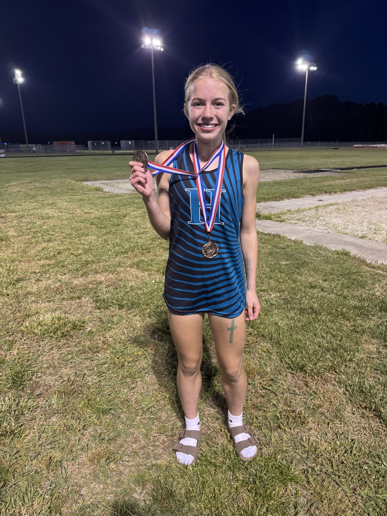 track student athlete proudly standing with their medal