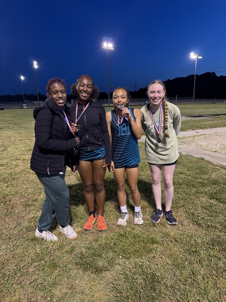 track student athletes proudly standing with their medal