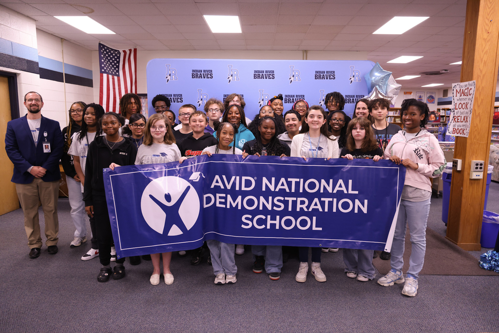 Students and administrators excited about being awarded an AVID National Demonstration School and holding a big banner!