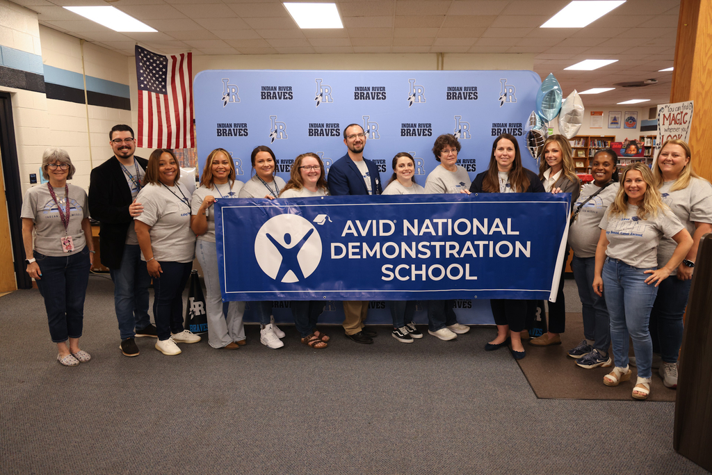 Teachers and administrators Students and administrators excited about being awarded an AVID National Demonstration School and holding a big banner!