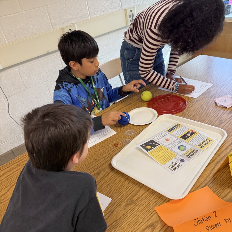 students working together to order objects based on the size of the planets.
