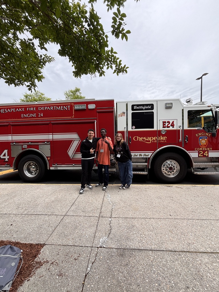 three smiling students standing in front of Chesapeake Fire  truck