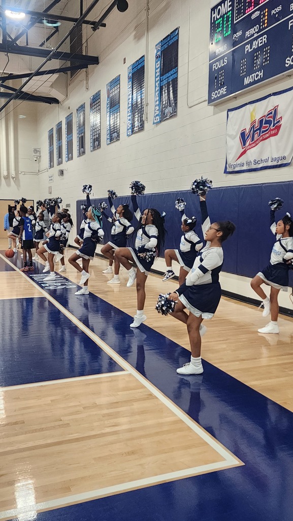 Cheerleaders cheering on the back of the court during the game.