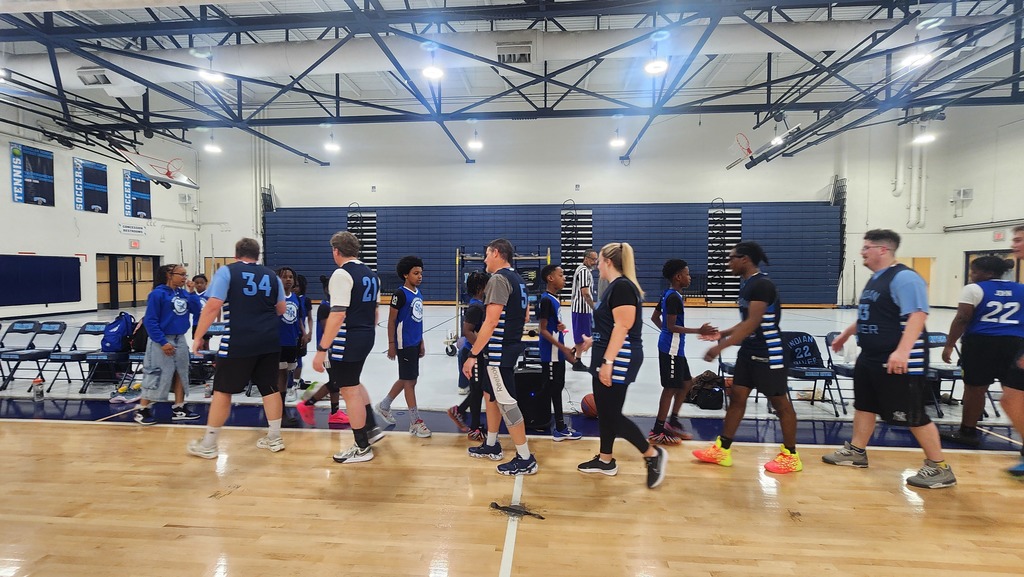 Both teams at the end of the game walking past each other to say good game.