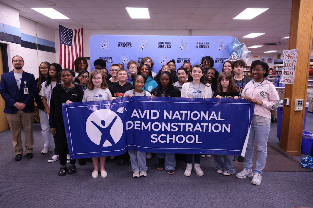middle school students and administrators standing with an AVID National Demonstration School banner