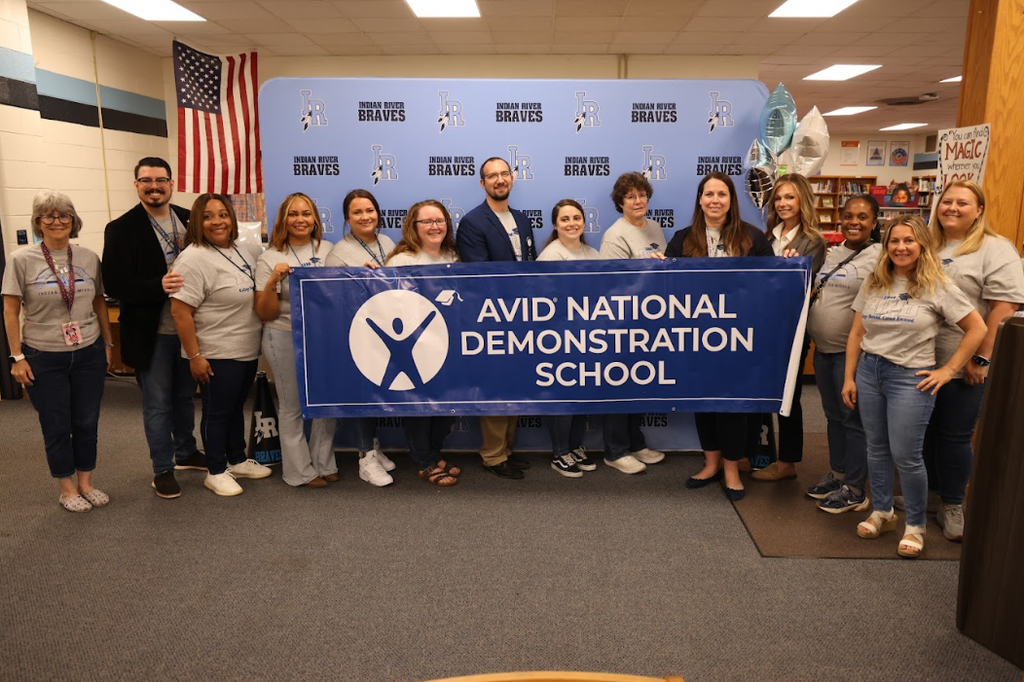 middle school staff and administrators standing with an AVID National Demonstration School banner