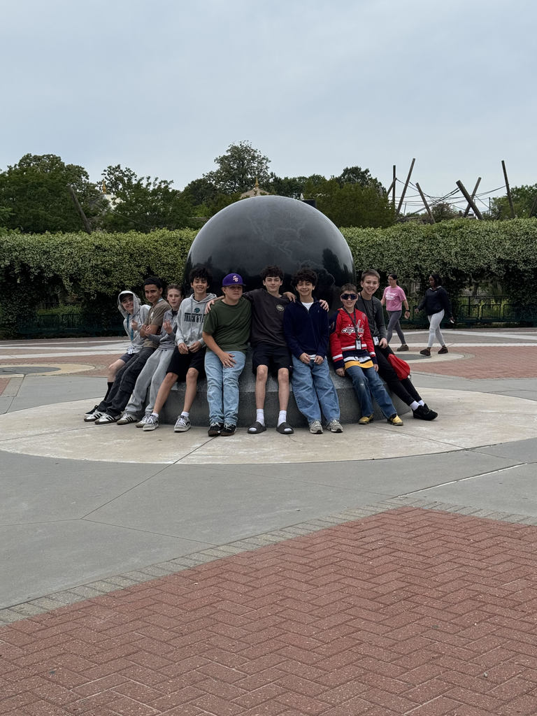 students sitting around a fountain at the zoo