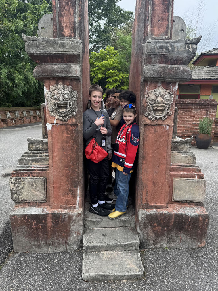 students squeezed inside two columns at the zoo