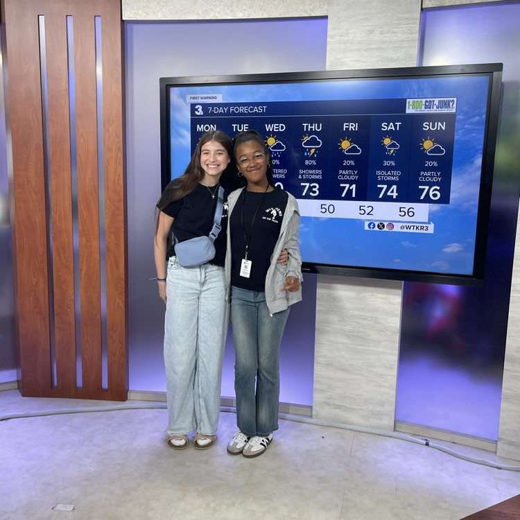 smiling students in news room