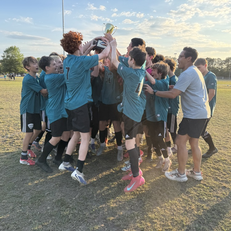 boys soccer team celebrating with the city championship trophy