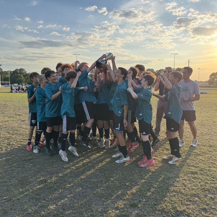 boys soccer team celebrating with the city championship trophy