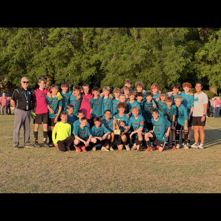 boys soccer team and coach and principal posing with the city trophy
