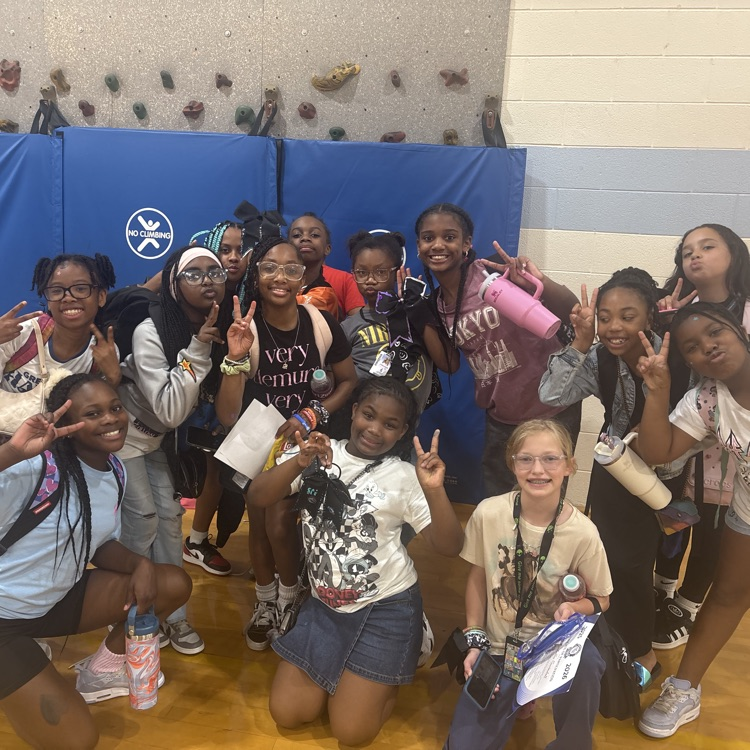 SRI cheer team at the end of season celebration in the gym and posing together with peace signs. 