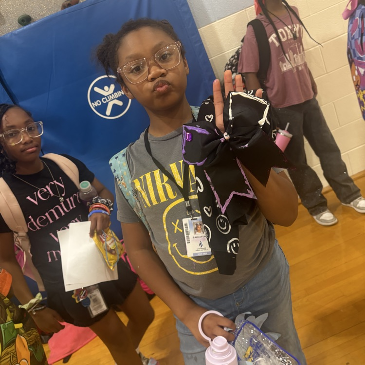 Student holding up decorated bow. 