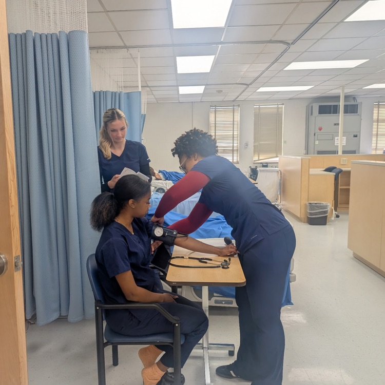 nurse aide students taking blood pressure 