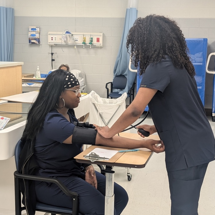nurse aide students taking blood pressure 