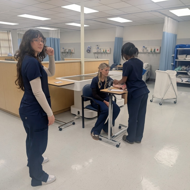 nurse aide students taking blood pressure 