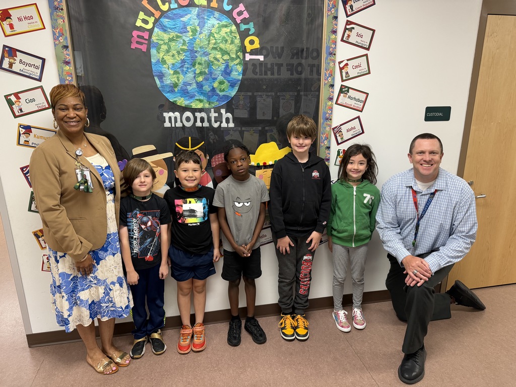 April Students of the Month from second grade, selected for demonstrating cooperation, standing together with school administrators while smiling for a group photo.