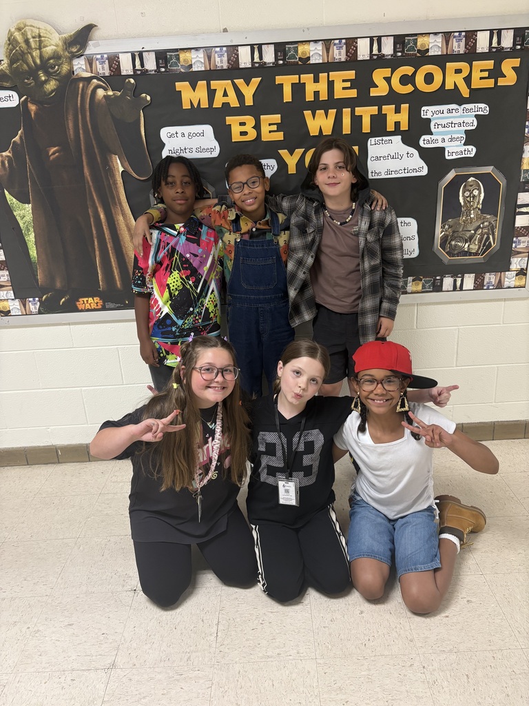 Class standing against wall with 90s wear