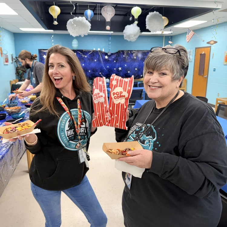 teachers happily posing with their candy and popcorn
