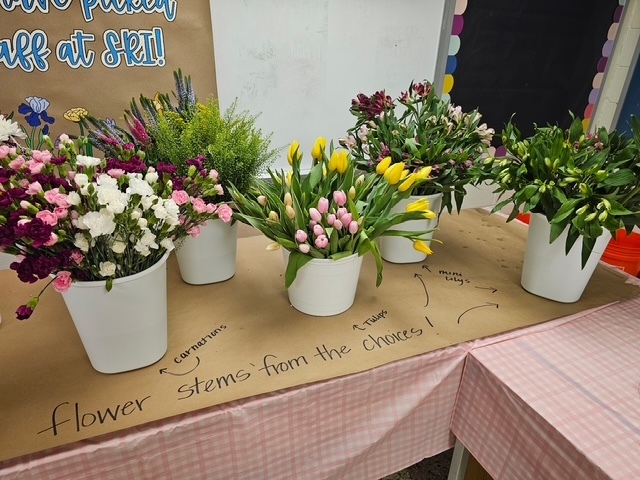 Flowers in buckets that are labels with the types of flowers to select from.
