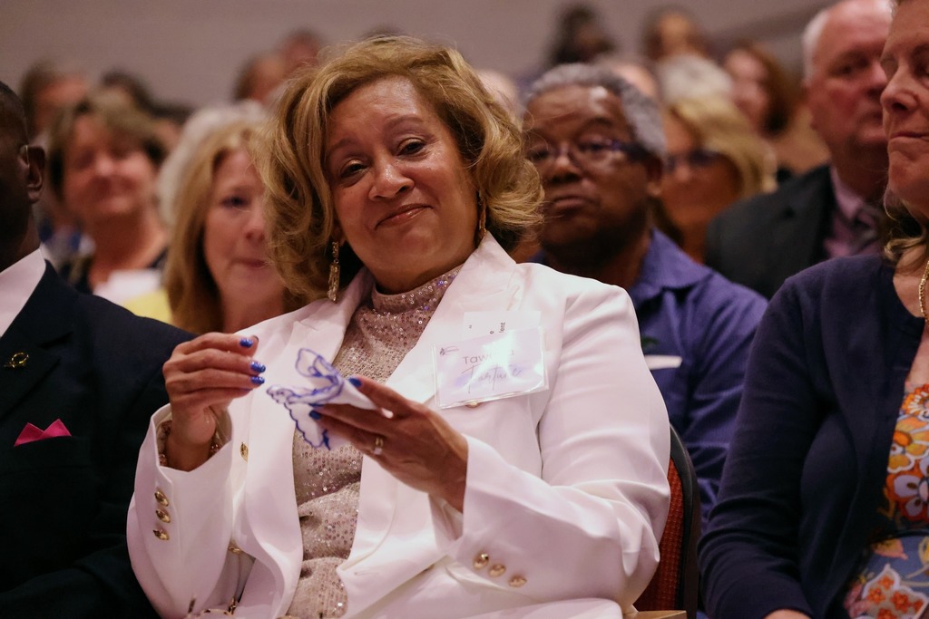 A retiree crying in a happy way for being honored for her contributions.
