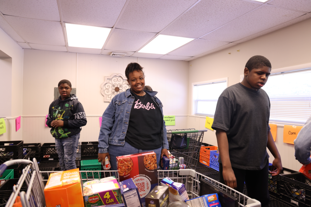 Students and teachers happily collect and sort community donations