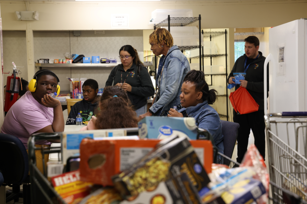 Students and teachers happily collect and sort community donations