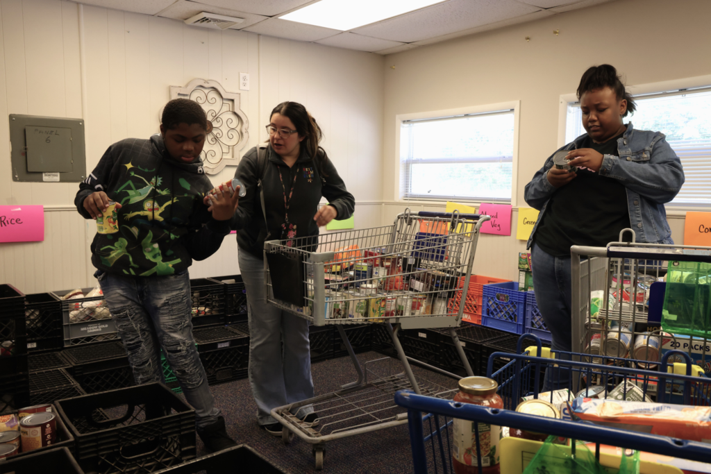 Students and teachers happily collect and sort community donations
