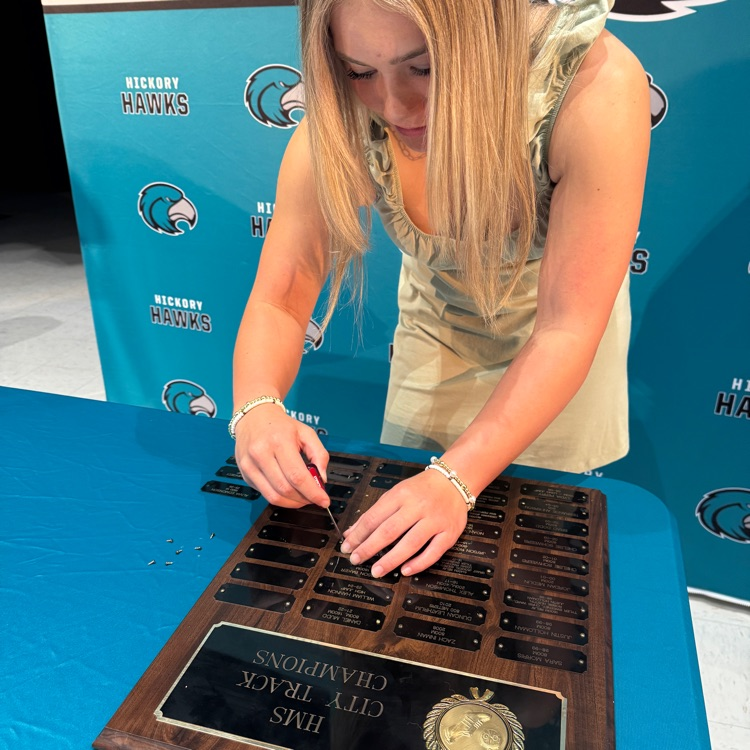 students placing their nameplate on the plaque