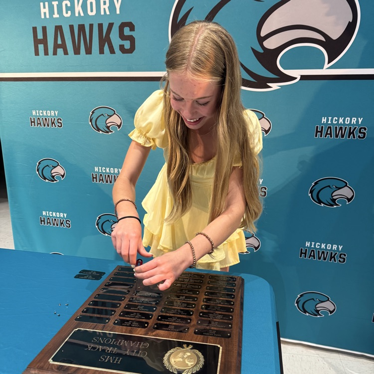 students placing their nameplate on the plaque