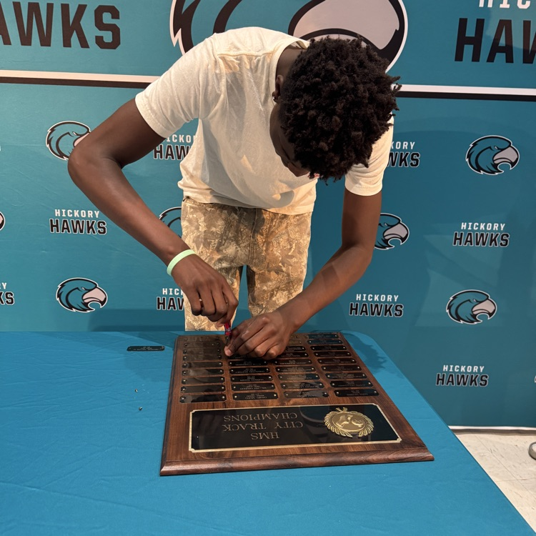 students placing their nameplate  on the plaque