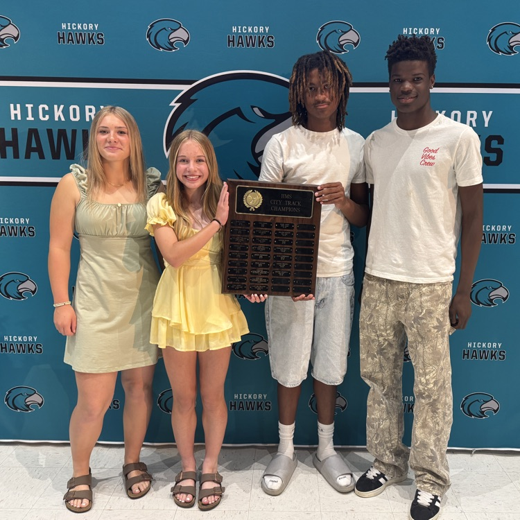 students posing with plaque